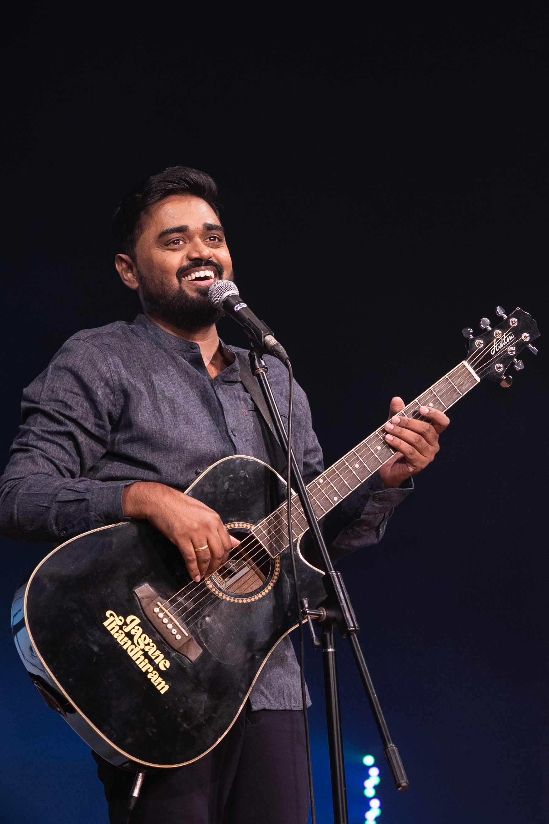Jagan Krishnan performing his stand-up special Jagane Thandhiram with a guitar